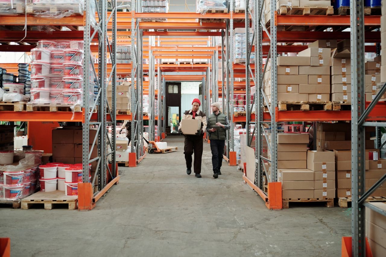 Warehouse aisle with racking, pallets and two operatives